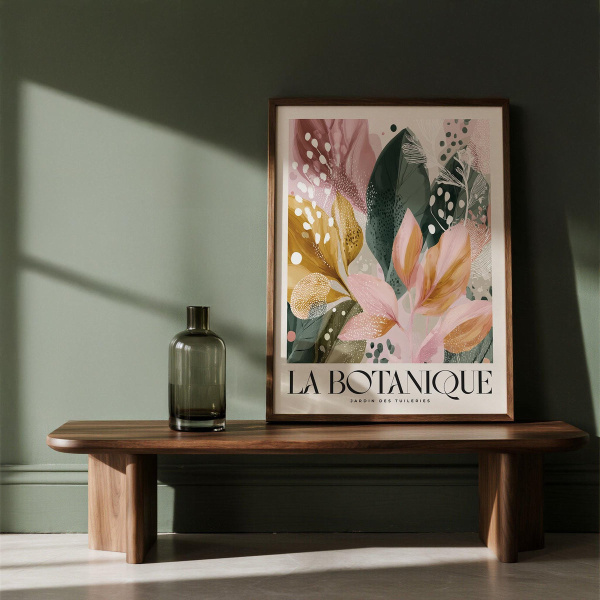 Modern Flower wall art with abstract botanical leaves in pink and green leaning on a wooden bench with a glass vase