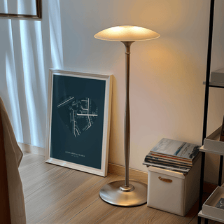 Love Map Poster leaning on the floor with a white frame next to a floor lamp and stack of books