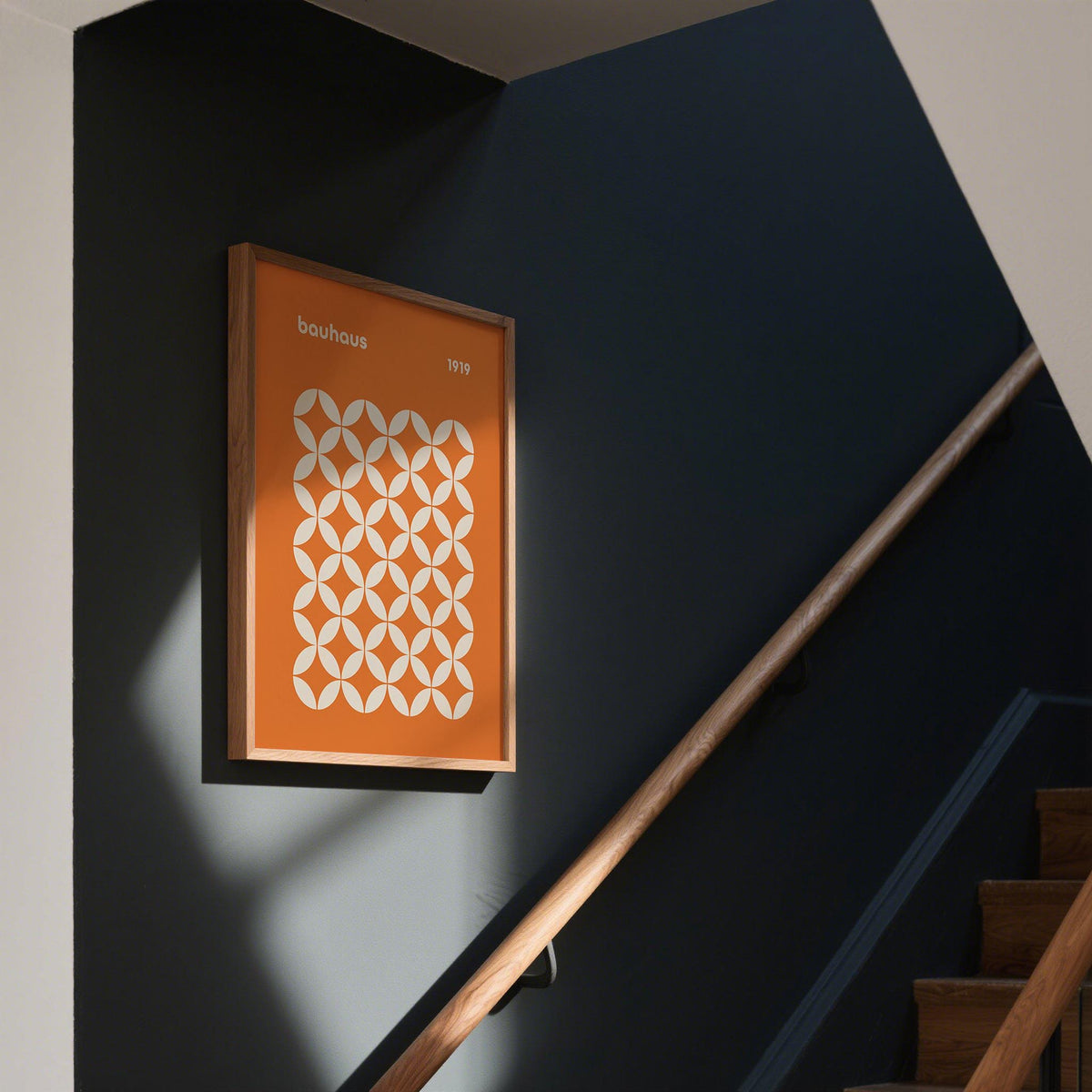 Orange Poster framed print with a white circle grid pattern in minimalist style on a dark wall by stairs