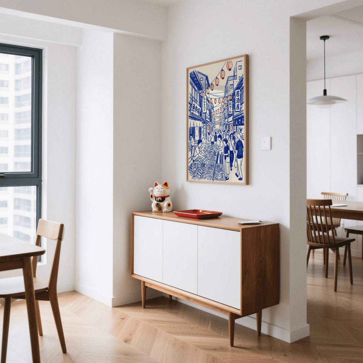 Print of Japanese street market art hanging above a sideboard with a lucky cat ornament