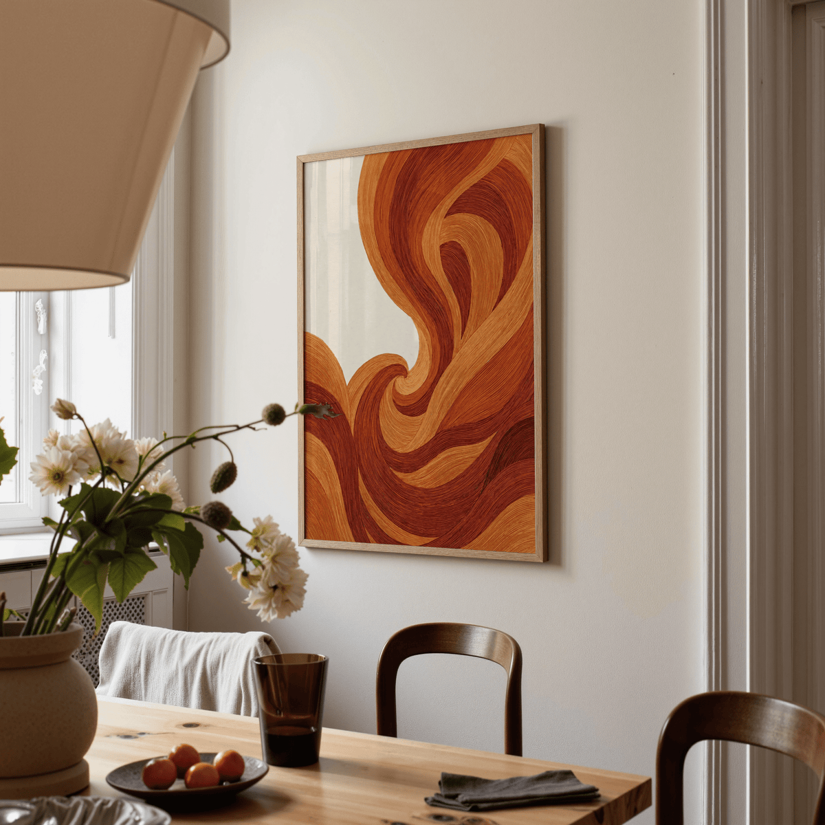 Print on a wall of abstract wave art print with swirling brown and orange lines in a dining room with wooden table