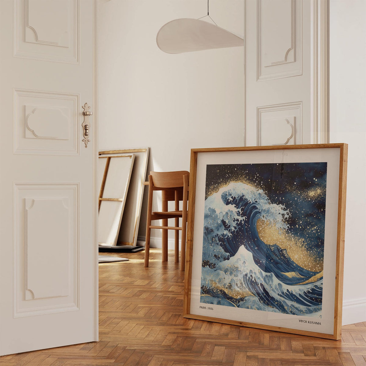 Print leaning on a wooden floor of the ocean wave illustration with blue and gold tones