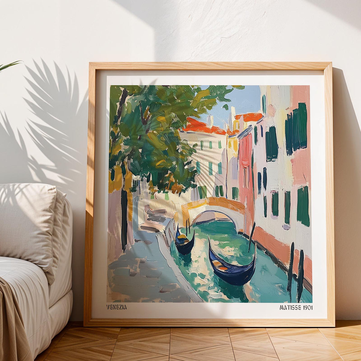 Framed Venice wall art depicting gondolas on a canal with green and pink tones beside a sofa
