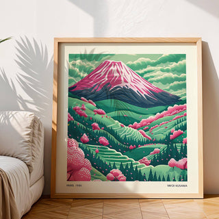 Framed Mountain Landscape Art showing Mount Fuji with pink cherry blossoms and green hills leaning against a wall next to a beige sofa