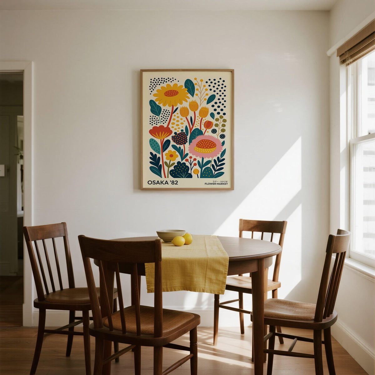 Spring Print framed on a white wall above a dining table with wooden chairs and yellow runner