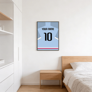 Football Shirt Poster in Light Blue with Black Number hanging above a wooden bedside table in a bedroom