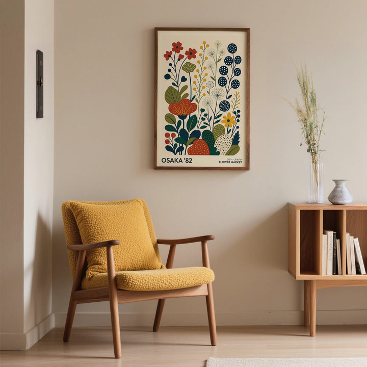 Nature artwork framed print of stylised colourful flowers above a mustard armchair in a living room