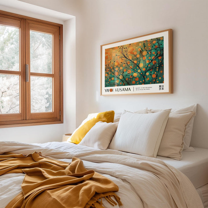 Autumn wall art framed print with abstract branches in orange and teal above a cream bed with cushions