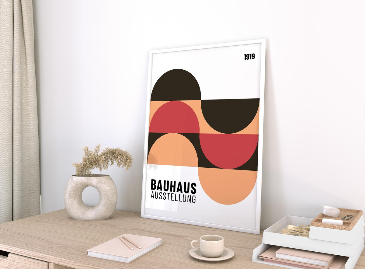 Home Office Wall Art leaning on a wooden desk with beige, black and red geometric shapes and a decorative vase nearby