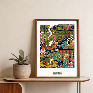 Japanese Frog Art Print framed on a wooden table next to a small potted plant with green leaves
