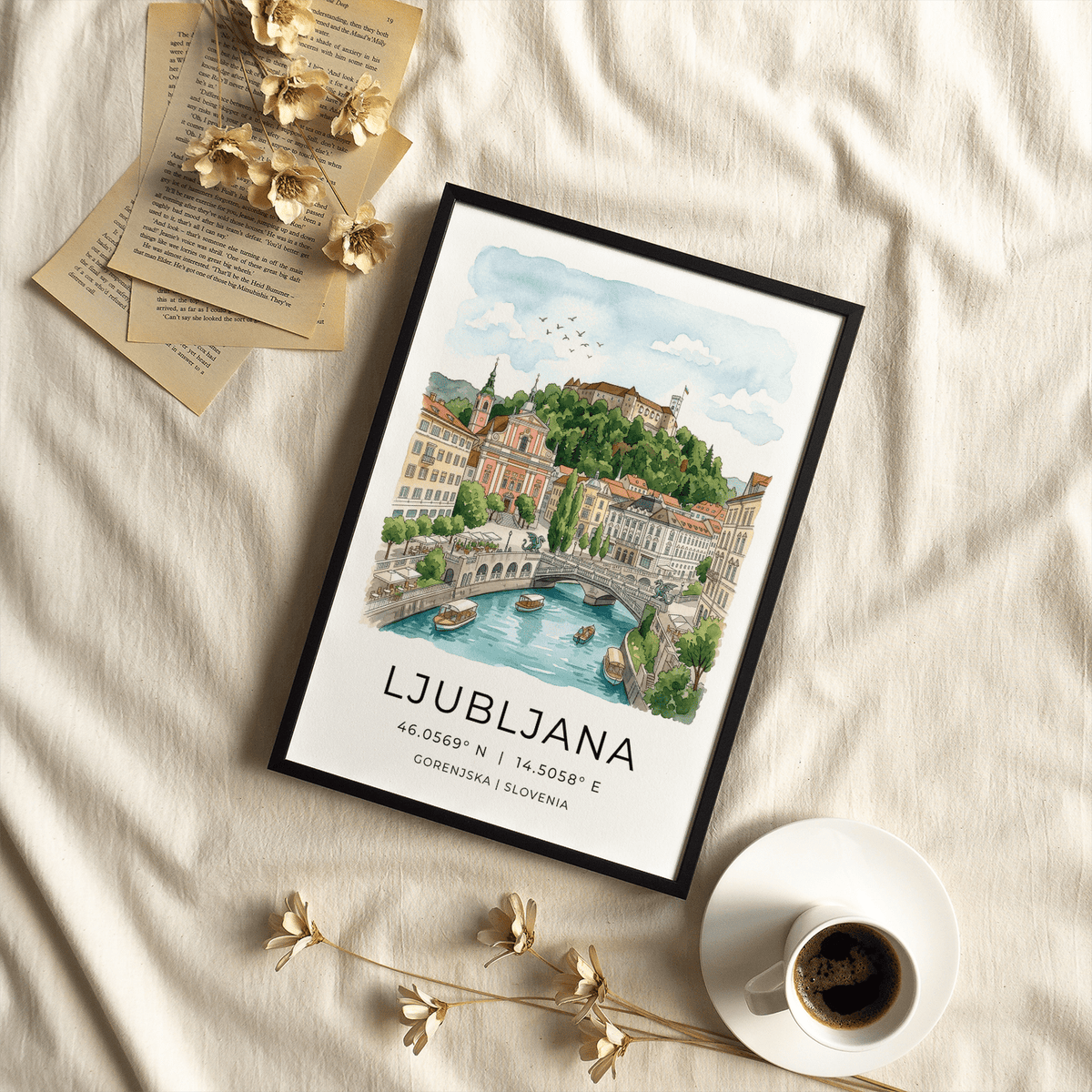 Framed Ljubljana Art Print showing a river view with boats and buildings on a beige fabric with coffee cup