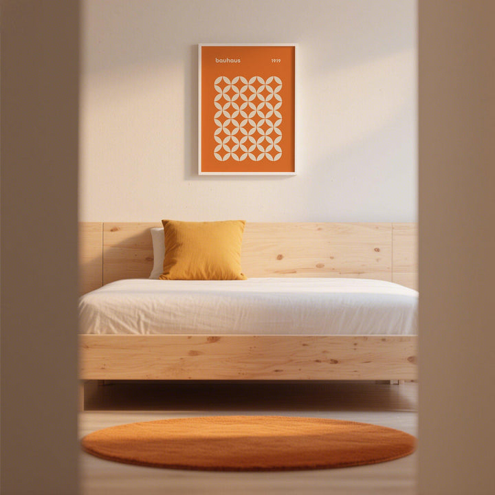 Orange Poster framed print with a circle grid pattern in bauhaus style above a bed with an orange cushion and round rug in a bedroom