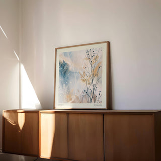 Neutral Prints framed print of an abstract botanical illustration in soft blues and beiges on top of a wooden sideboard