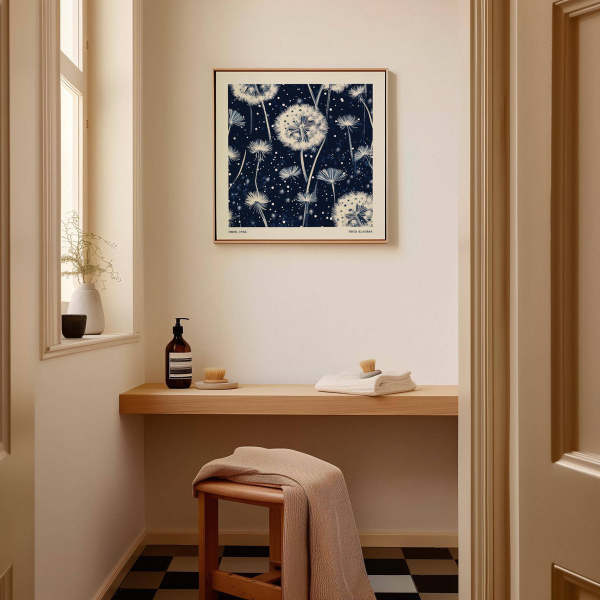 Navy and White wall art of dandelion seed heads in a minimalist style above a wooden desk in a small room