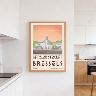 Art Deco Brussels Print hanging in a bright kitchen with wooden cabinets and white walls