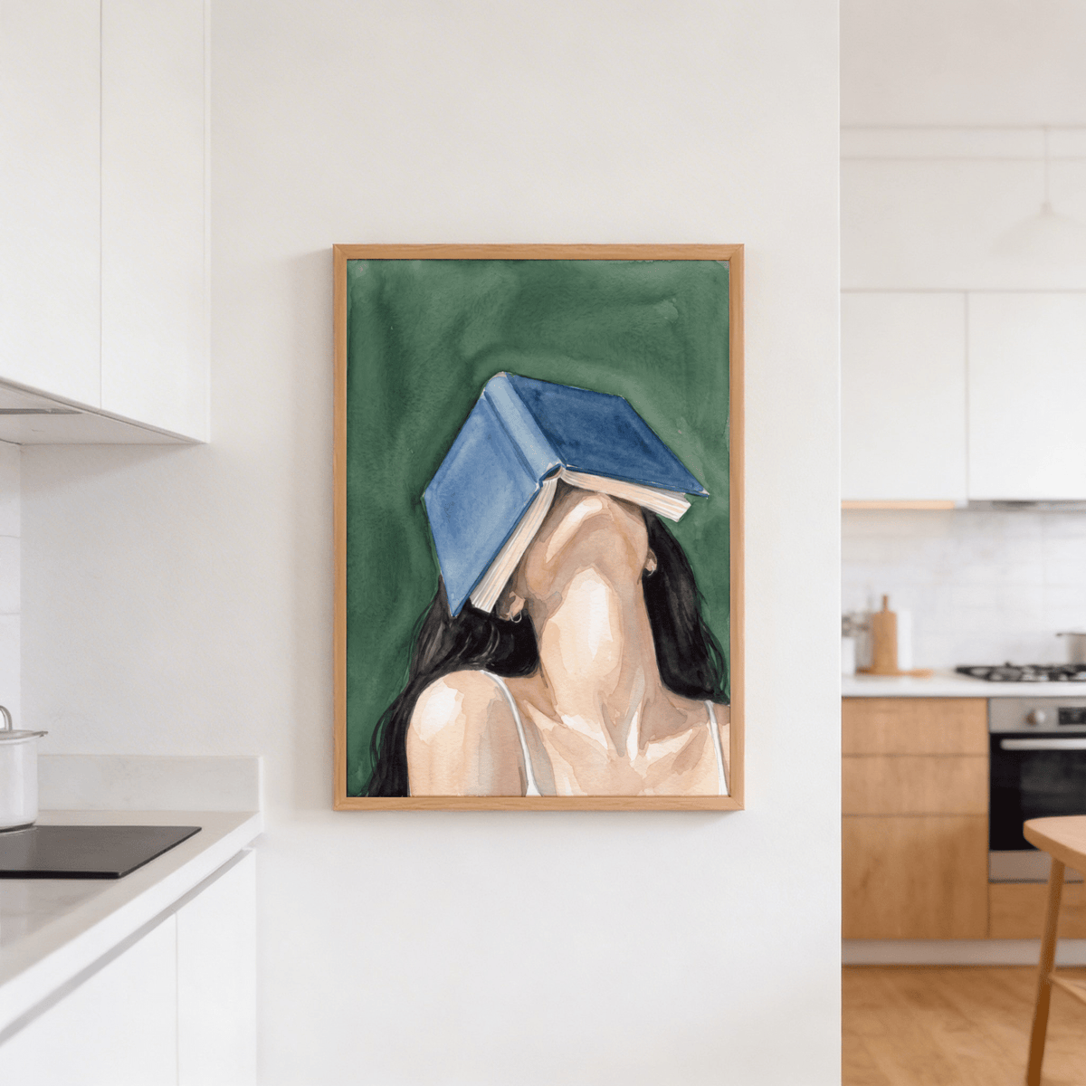 Print on a wall of a woman reading portrait with blue book and green background in a kitchen
