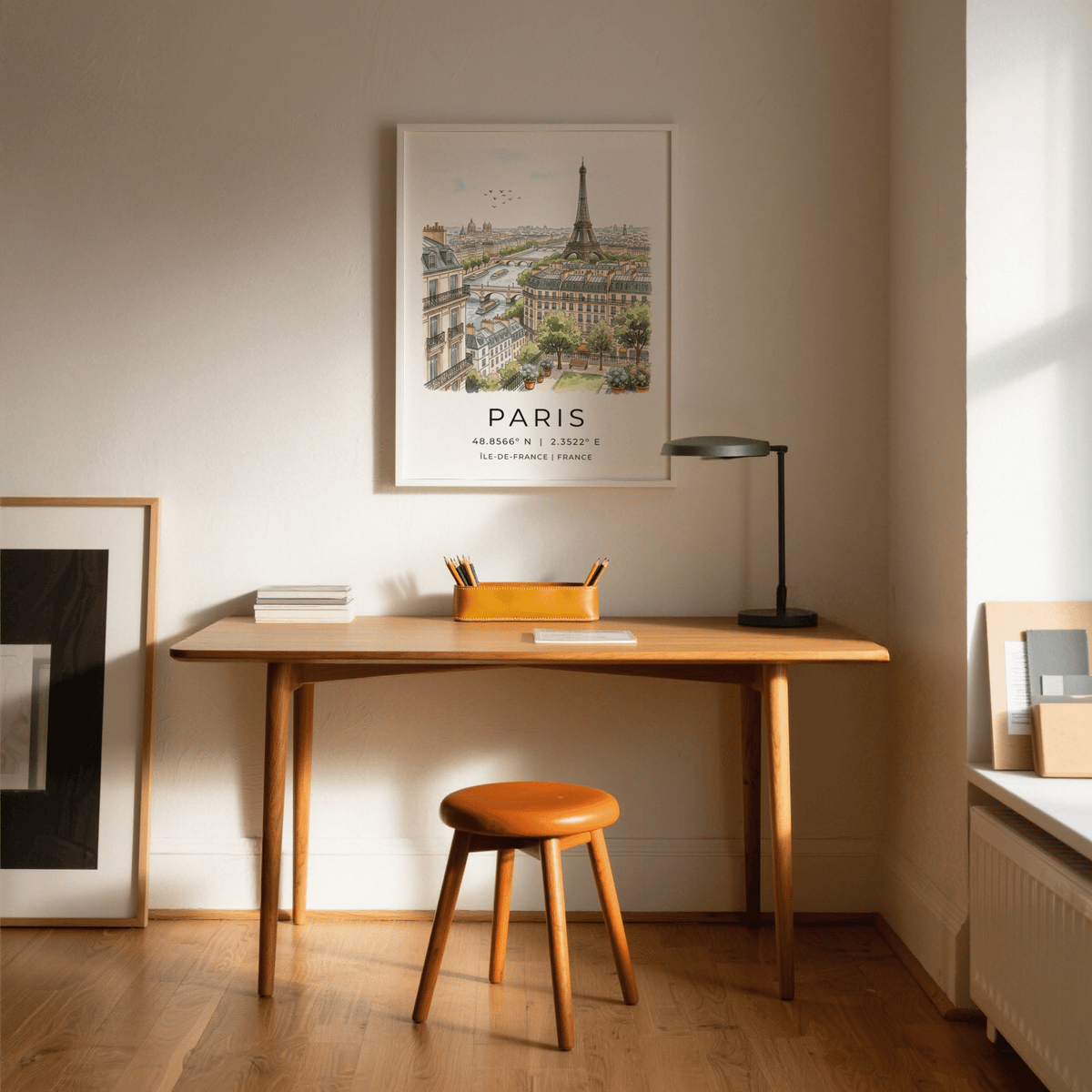 Paris Cityscape Art Print above a desk with a lamp and an orange organiser in a study