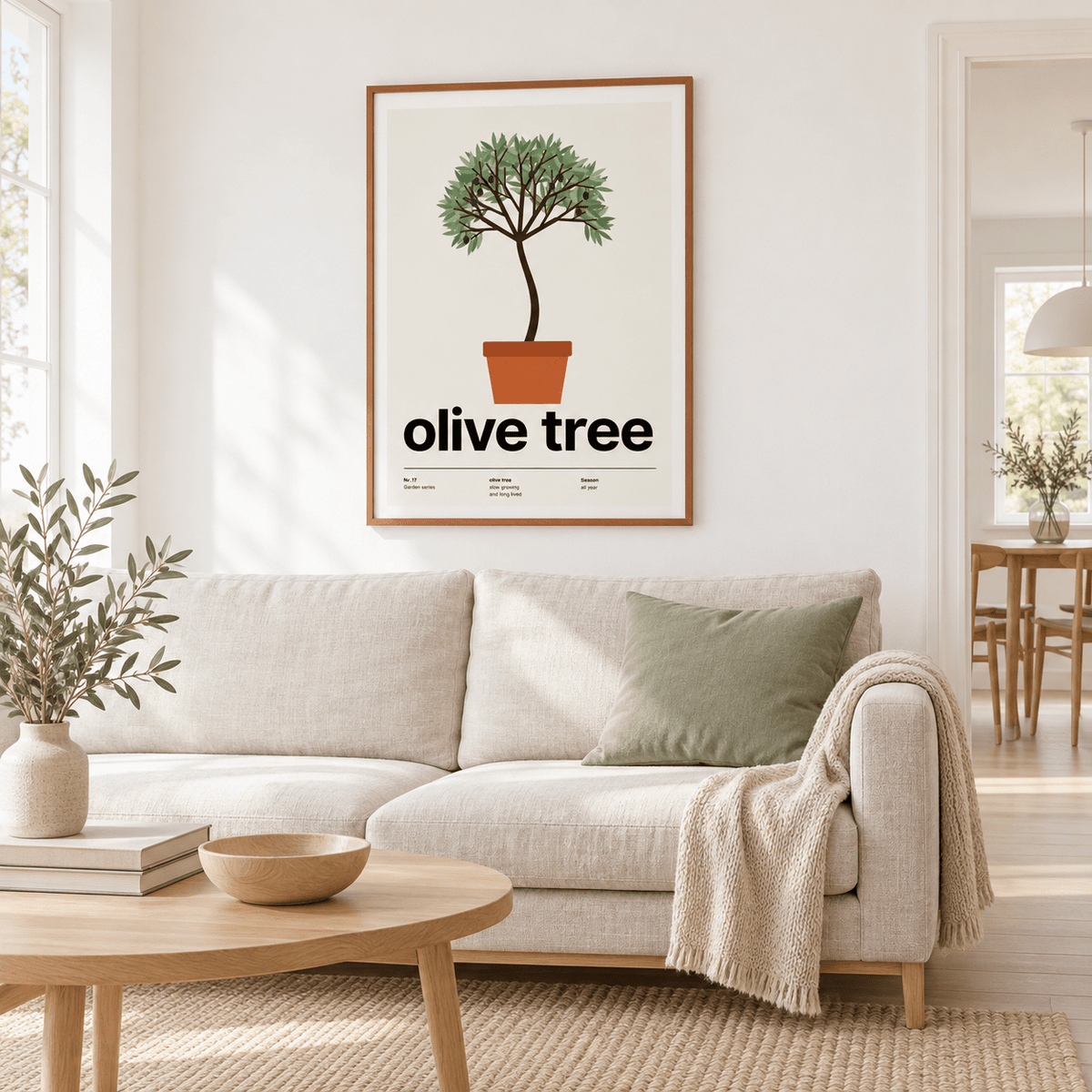Potted olive tree print above a sofa in a light living room