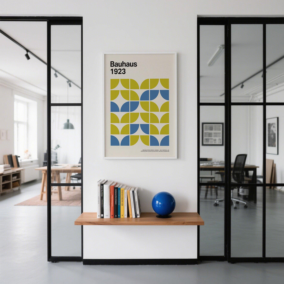 Bauhaus Geometric Art in lime green and blue above a wooden shelf with books and a blue spherical object in an office