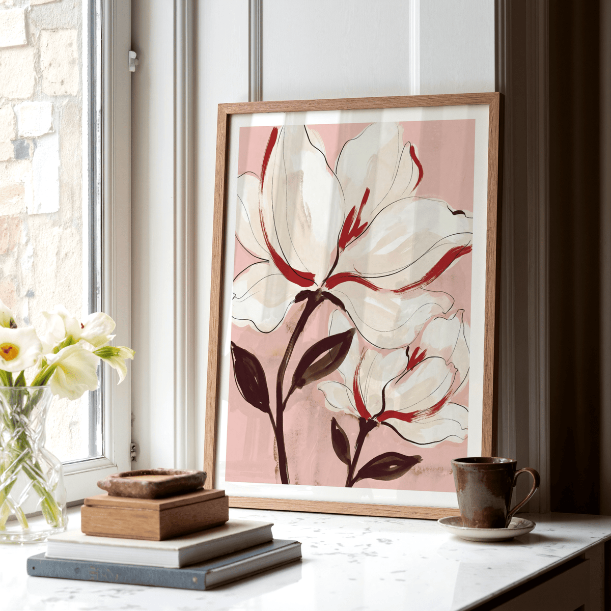 Flower Print leaning on a white marble window sill with a small brown cup and a glass vase of flowers