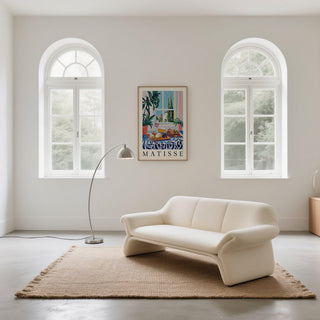 Print on a wall of French Prints showing an illustrated cheese and bread lunch with blue and pink tones in a bright living room