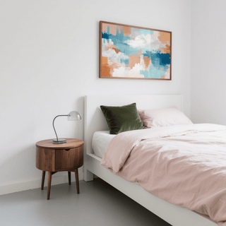 Abstract Cloud Print above a white bed with a green cushion and wooden bedside table in a bedroom
