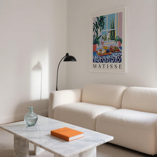 French Prints wall art of a cheese and bread lunch in a bright living room above a cream sofa
