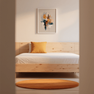 Colourful Wabi Sabi print with abstract shapes in muted tones above wooden bed with orange cushion