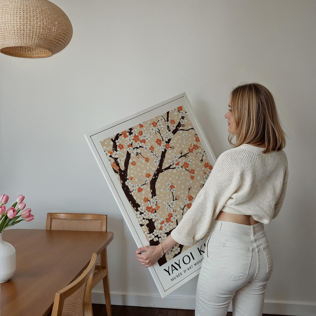 Framed Cherry Blossom Tree Art held by person showing floral branches in white and orange on beige background