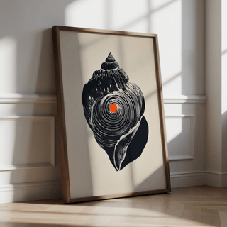 Framed Shankha Art Print leaning on floor with a black shell and orange dot in soft natural light