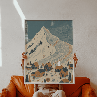 Framed Winter Mountain Art Print held by hands with blue sky and snowy mountain scene and wooden houses