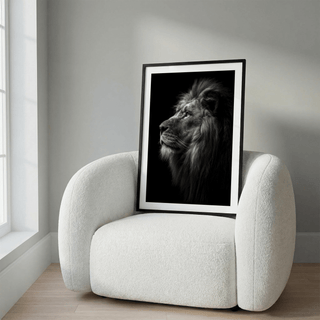 Lion wall art of a lion profile in black and white resting on a white textured armchair near a window