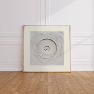 Surrealism Posters leaning print of concentric sand circles in soft grey shades on a wooden floor