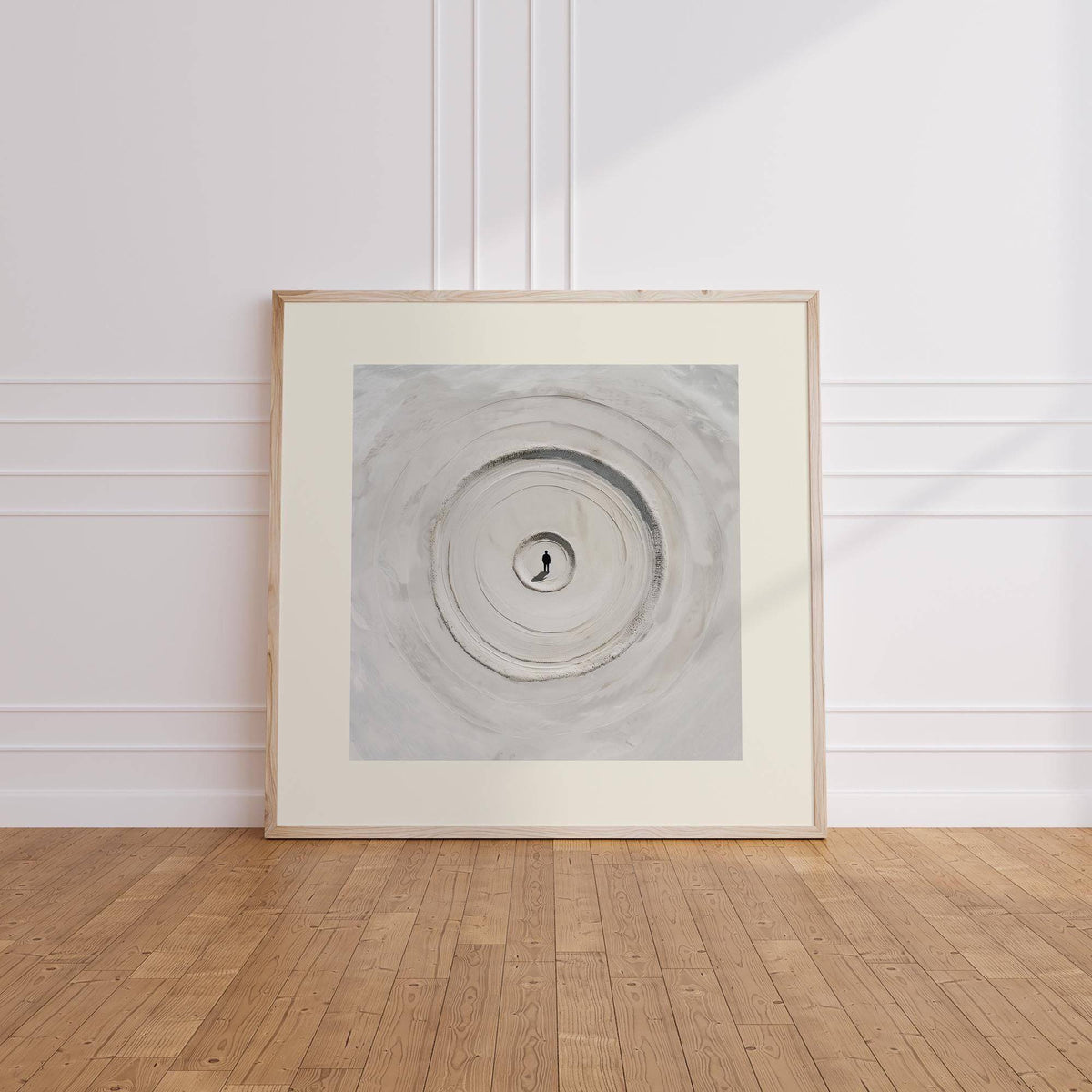 Surrealism Posters leaning print of concentric sand circles in soft grey shades on a wooden floor