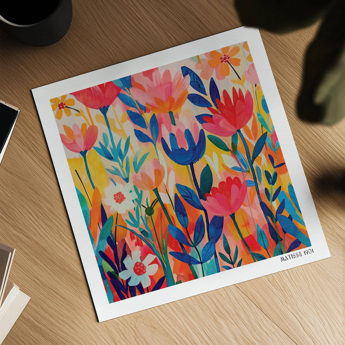 Close-up of Matisse Exhibition Poster with colourful minimalist flowers on a wooden table next to books