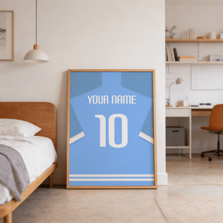 Football Shirt Poster in Light Blue with White Sleeve Stripes leaning on the floor by a bed in a bedroom