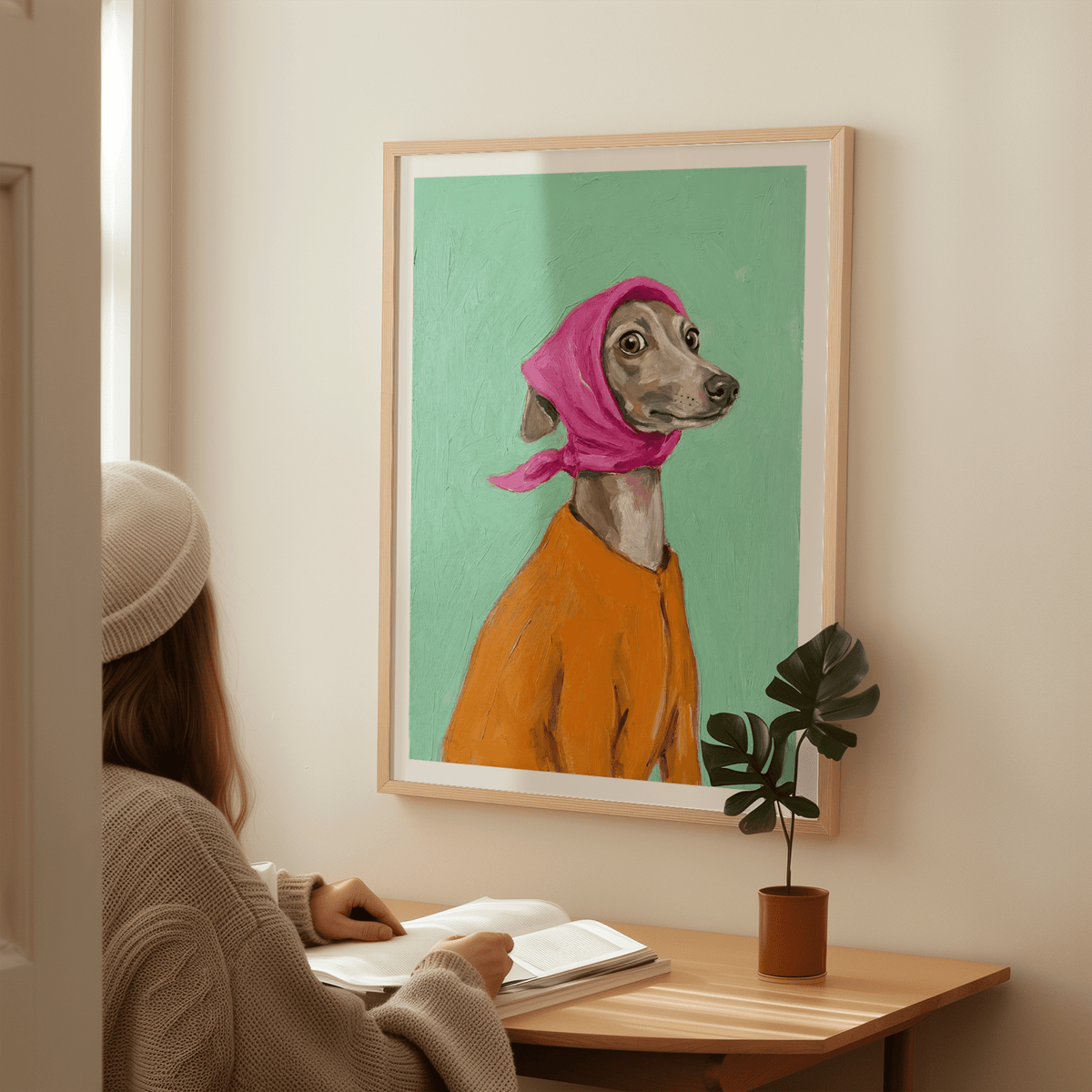 Greyhound Poster of a greyhound dog in a pink headscarf and orange coat above a wooden desk with a potted plant