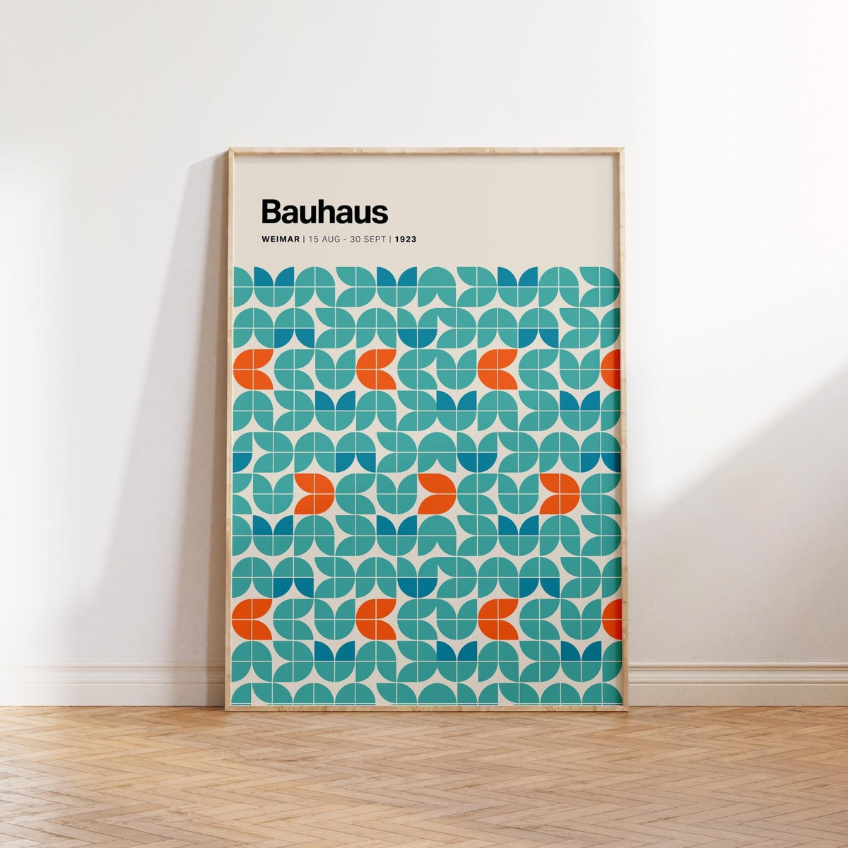 Framed Graphic Wall Art with blue and orange modular geometric pattern leaning on a parquet floor