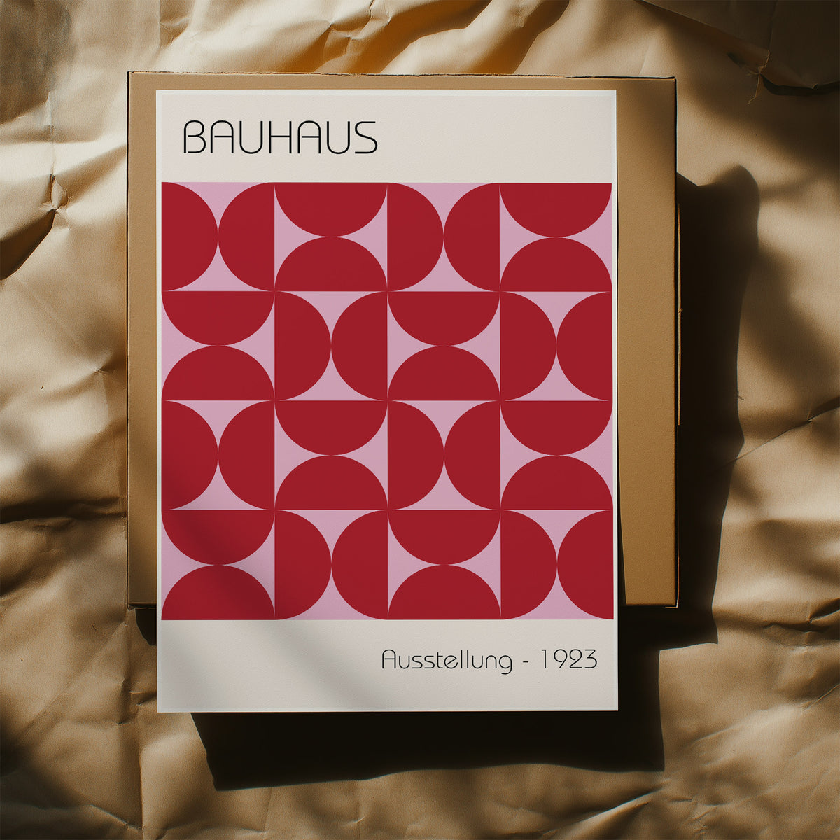 Bauhaus artworks print of red geometric shapes on pink and cream backdrop with typographic details on a box