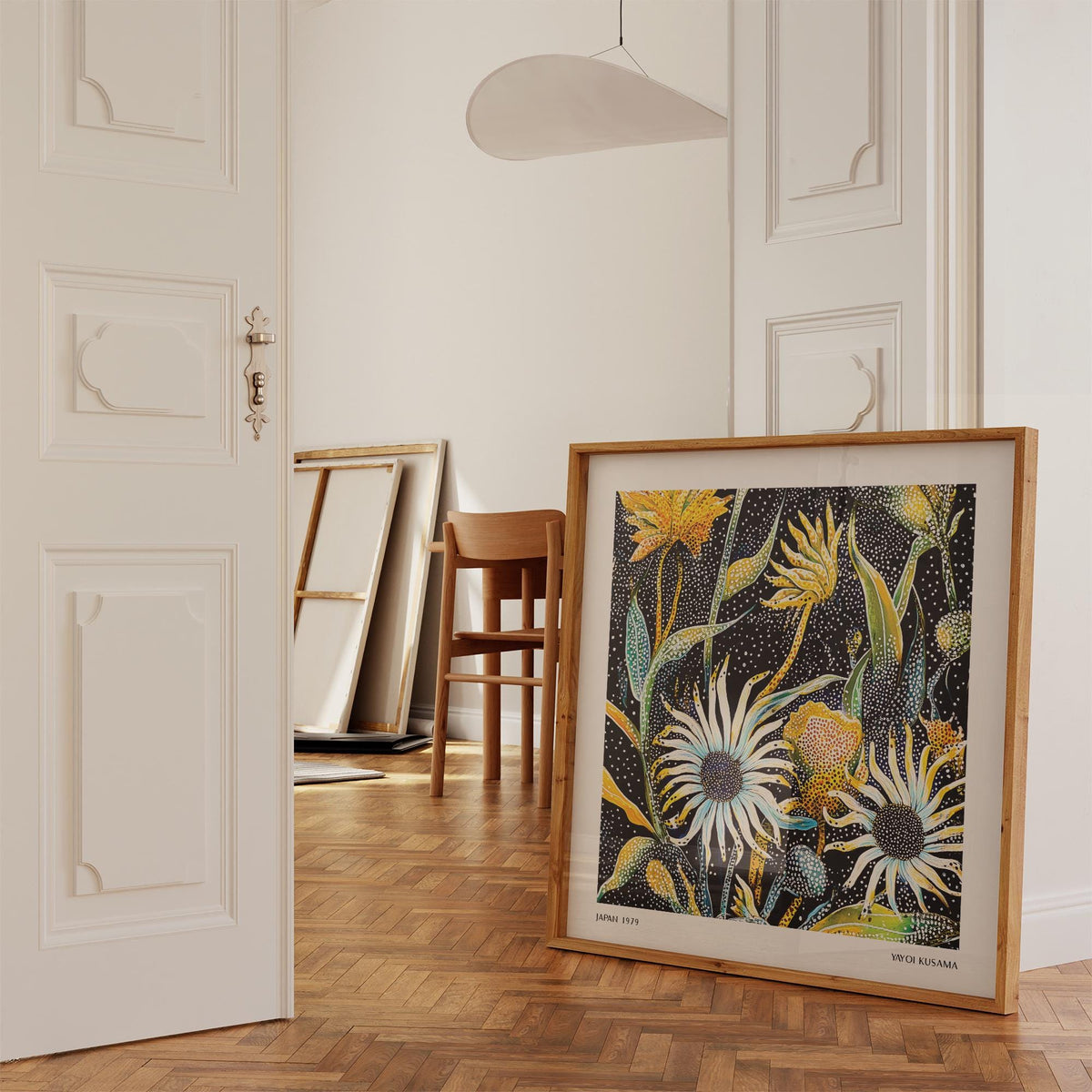 Abstract art floral print with yellow and white dotted flowers leaning on the floor in a room with wooden parquet