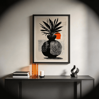 Modern Indian Sun Plant wall art in a black frame above a console table with decor including an orange vase and candle
