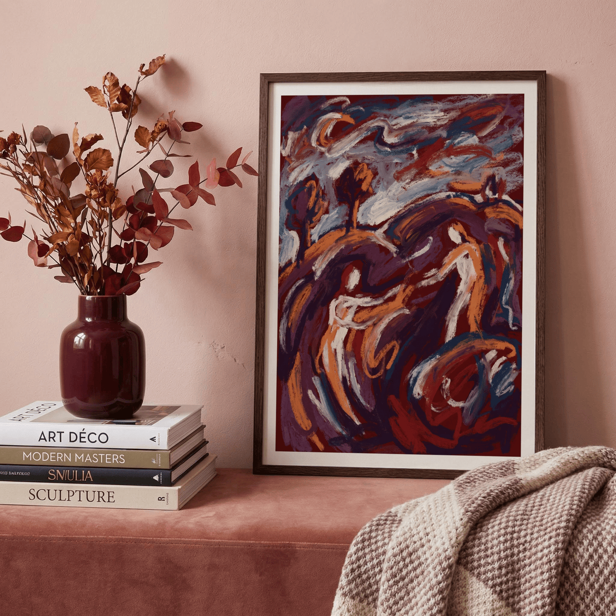 Framed Abstract Couple Art Print with orange and blue hues next to a vase with autumn leaves