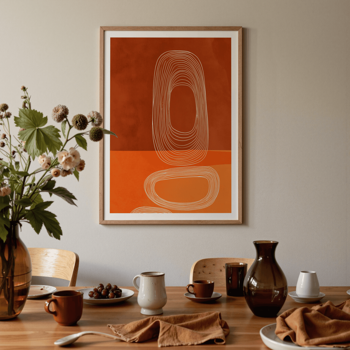 Abstract Line Art Print in warm orange and brown nested ovals above a dining table with crockery