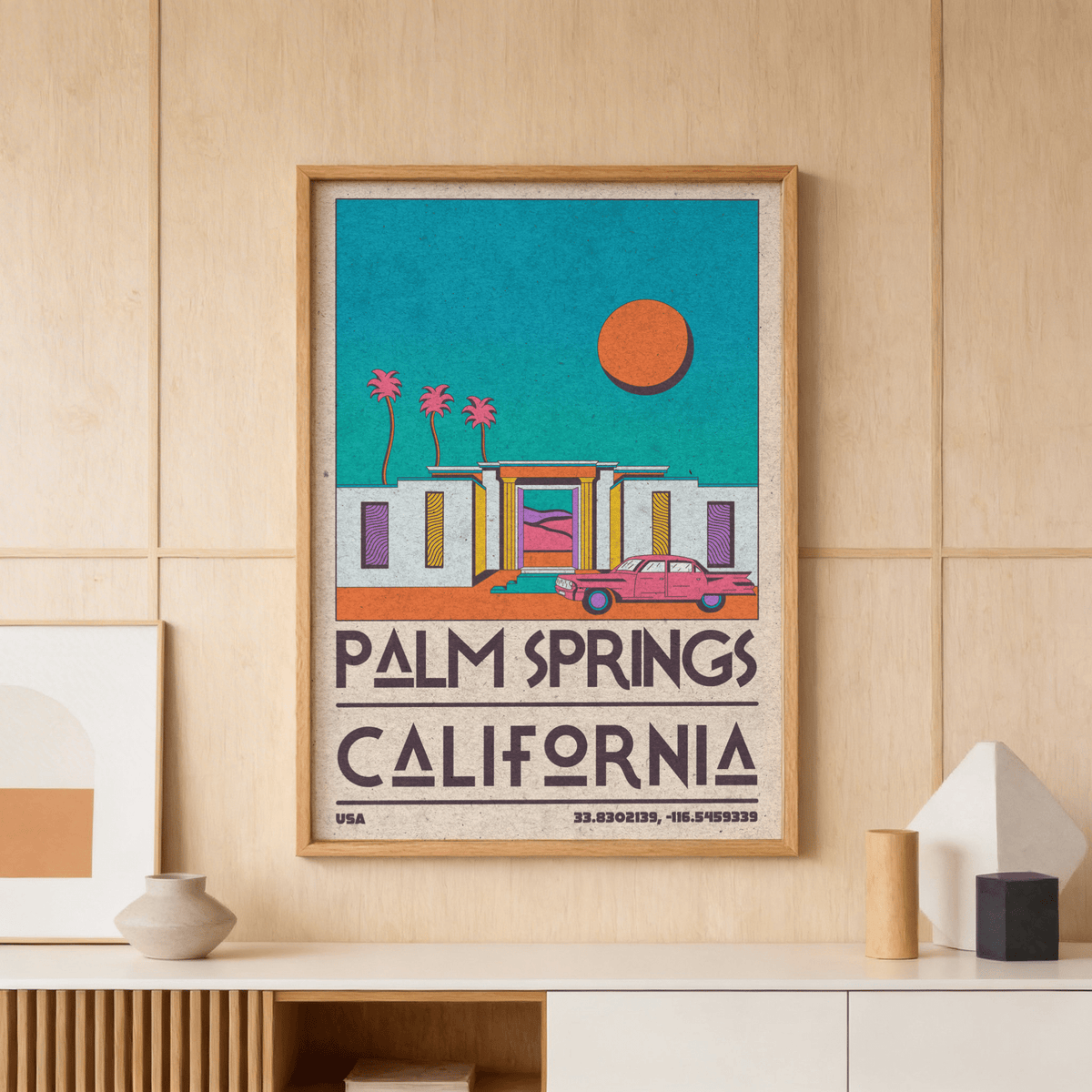 Palm Springs art print of a retro desert house with pink car and orange sun above a wooden sideboard with vases