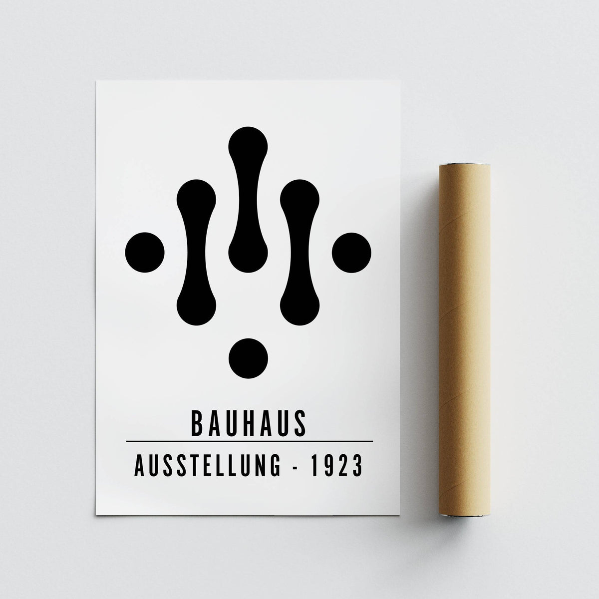 Bauhaus Art Black and White print flat with black abstract shapes next to a brown packaging tube