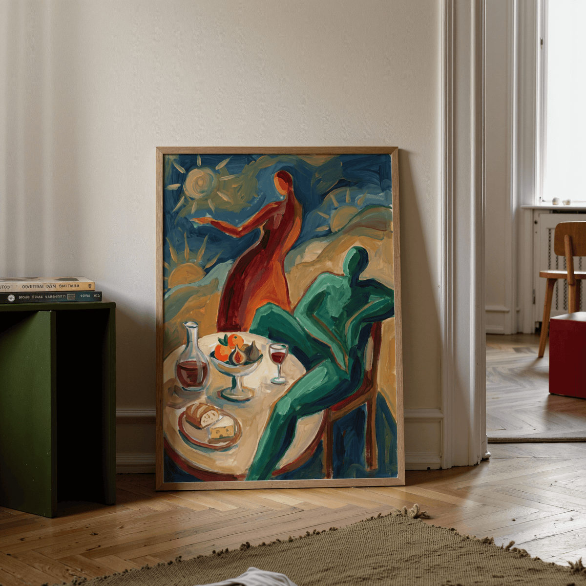 Print leaning on a wooden floor of abstract figures at a table with warm colours and books nearby