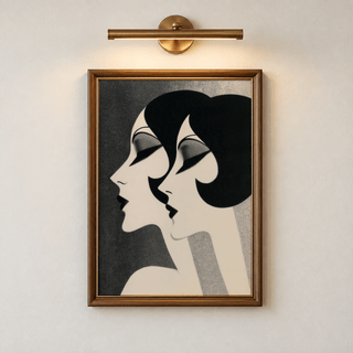 Art Deco Female Profiles Print in a wooden frame with a wall light above showing black and white stylised female profiles