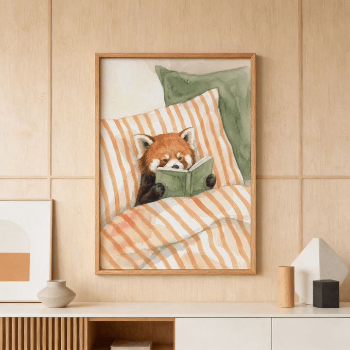 Red panda reading art print in watercolour style hung above a white sideboard with vases