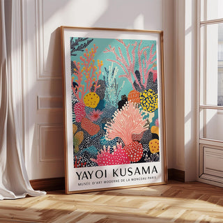 Bright wall art leaning on a wooden floor showing abstract coral reef with pink and yellow hues near a sunlit window