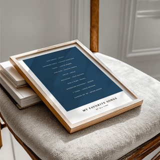Framed print of a typographic minimalist song list on a chair with books